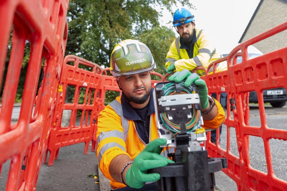 two engineers at work installing fibre in the street