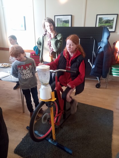 The children loved the smoothie bike. An old kitchen blender, with its motor removed, is powered by the wheel of another bastardised bicycle. One child pedals while another looks on.