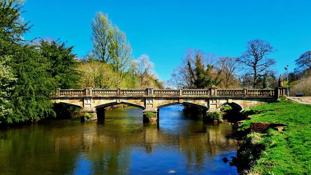 A stone bridge over a slow-flowing river.