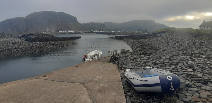 The view from the ferry slip on Easdale Island looking across to Seil. A thin mist hangs on the hills; to the east the sun is trying to break through.