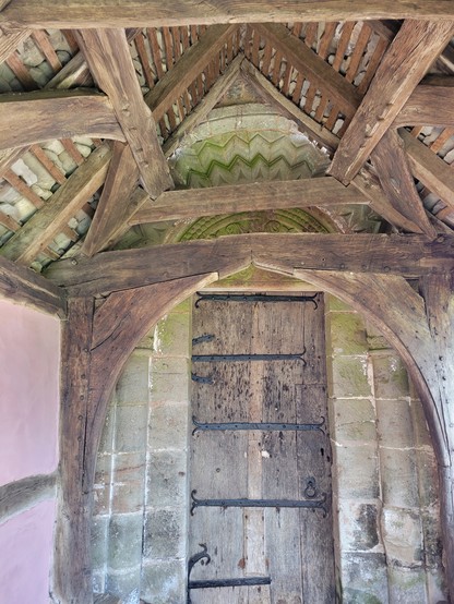 St Mary's Kempley. C14th porch abutting Norman arch. The porch has one pink wall.