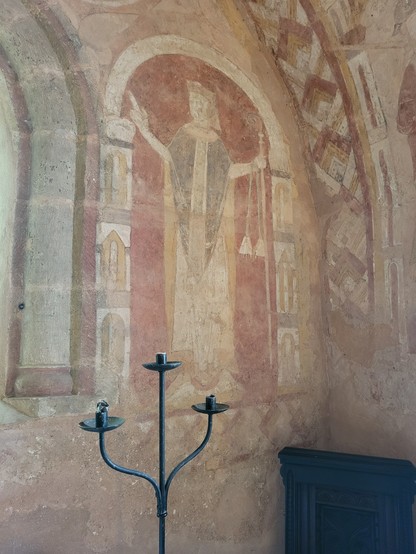 St Mary's Church Kempley. The medieval wall painting shows a full length depiction of a cleric.