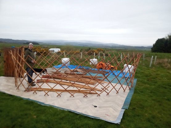 Wall trellis erected. The yurt is being erected on tarpaulins which are covered in carpet which in turn is being covered in linoleum. I am anxious that this will not be sufficient if we have a wet summer, but it's better than nothing.