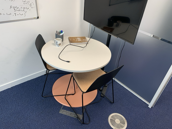 A table with two chairs, sitting on a blue floor
