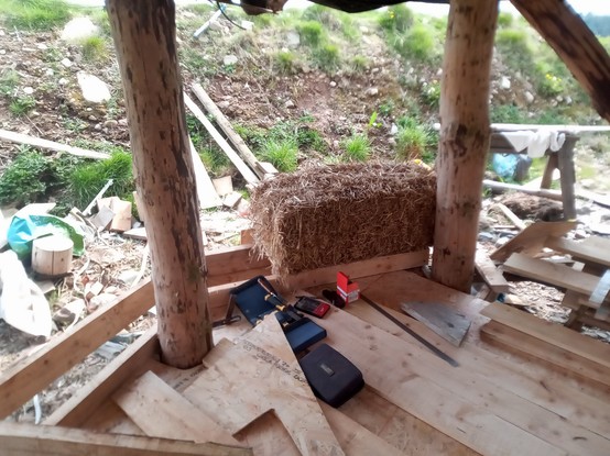 The first bale is placed on a box outrigged on the ends of the primary joists outside the ring of pillars. This view is from inside the house.