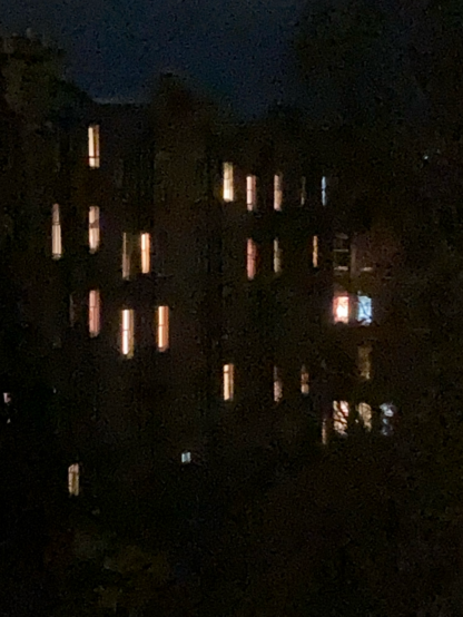 Image shows and moustache of illuminated windows against an almost black background