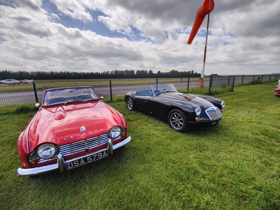 Red Triumph convertible on the left, British racing green convertble MG on the right