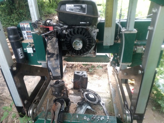 To remove the black cover, I had to take off the air cleaner, the carburettor, the exhaust, a heat shield, and loosen the fuel tank.

I've only lost one bolt down inside the motor so far!

In this picture the coil is visible just inside the opened black cover.