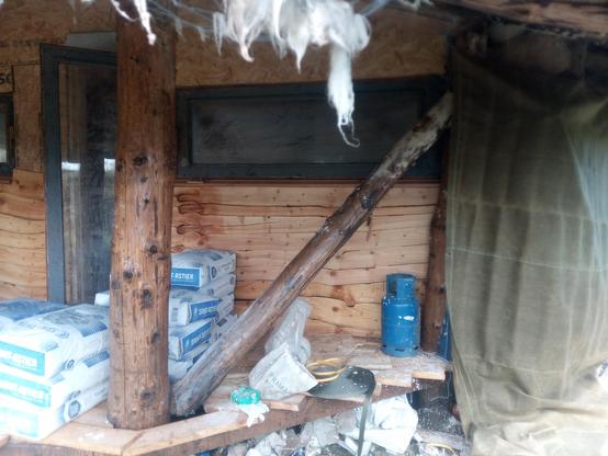 The end of the Hessian curtain at the south end of the front of the house, with bags of as-yet unused lime stacked on the decking of the porch.