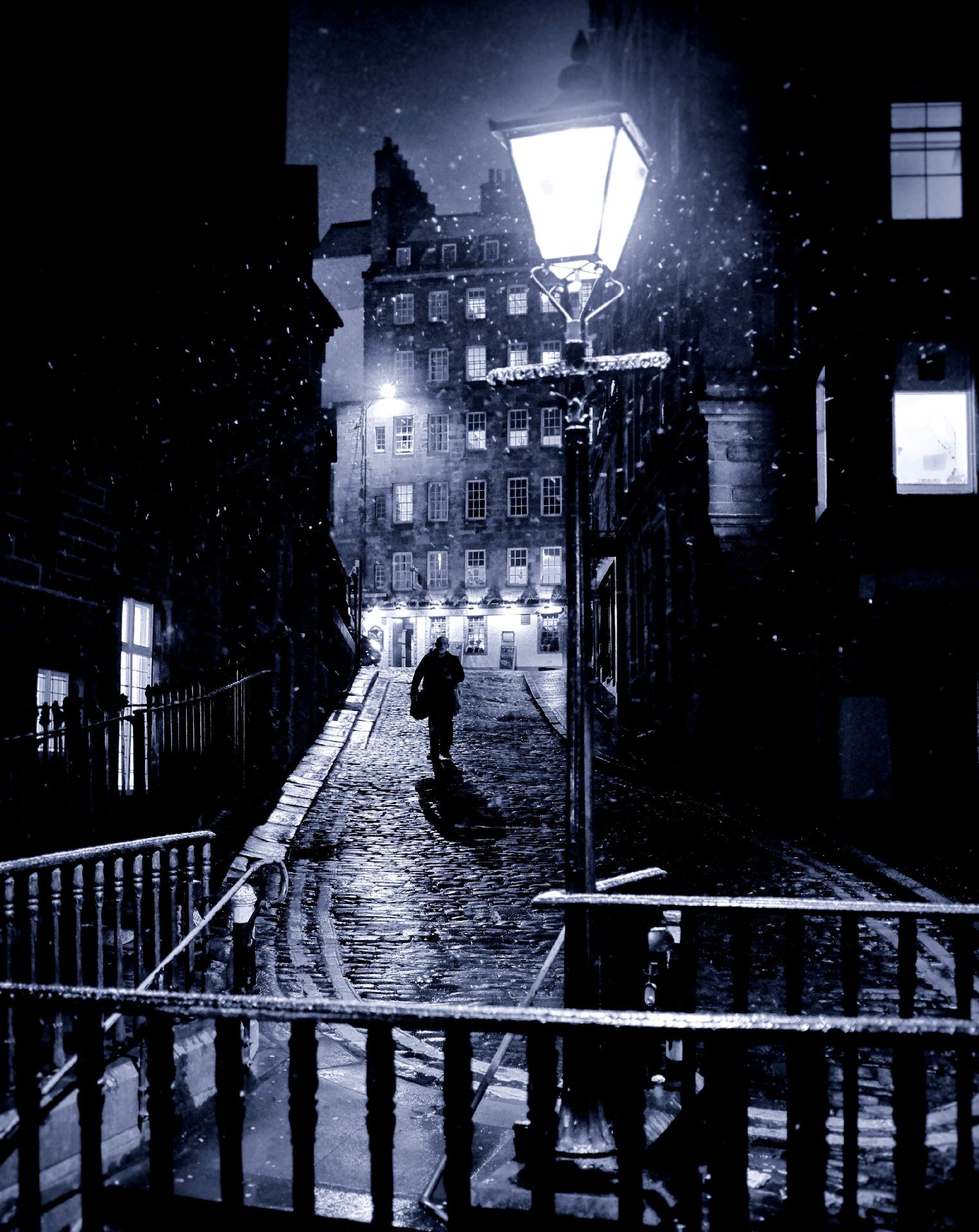 A lone figure walks down Upper Bow in the snow A lone figure walks down Upper Bow in the snow